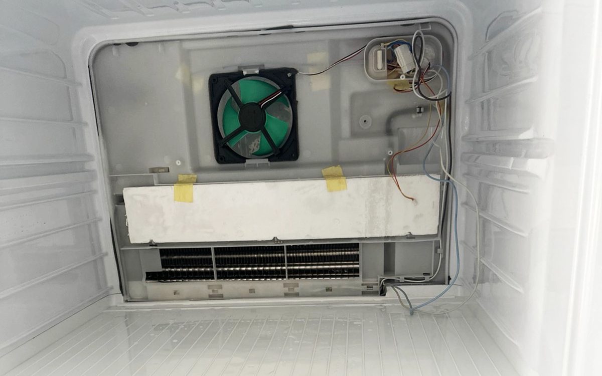Снятая задняя панель морозилки: вентилятор No Frost и испаритель перед ремонтом